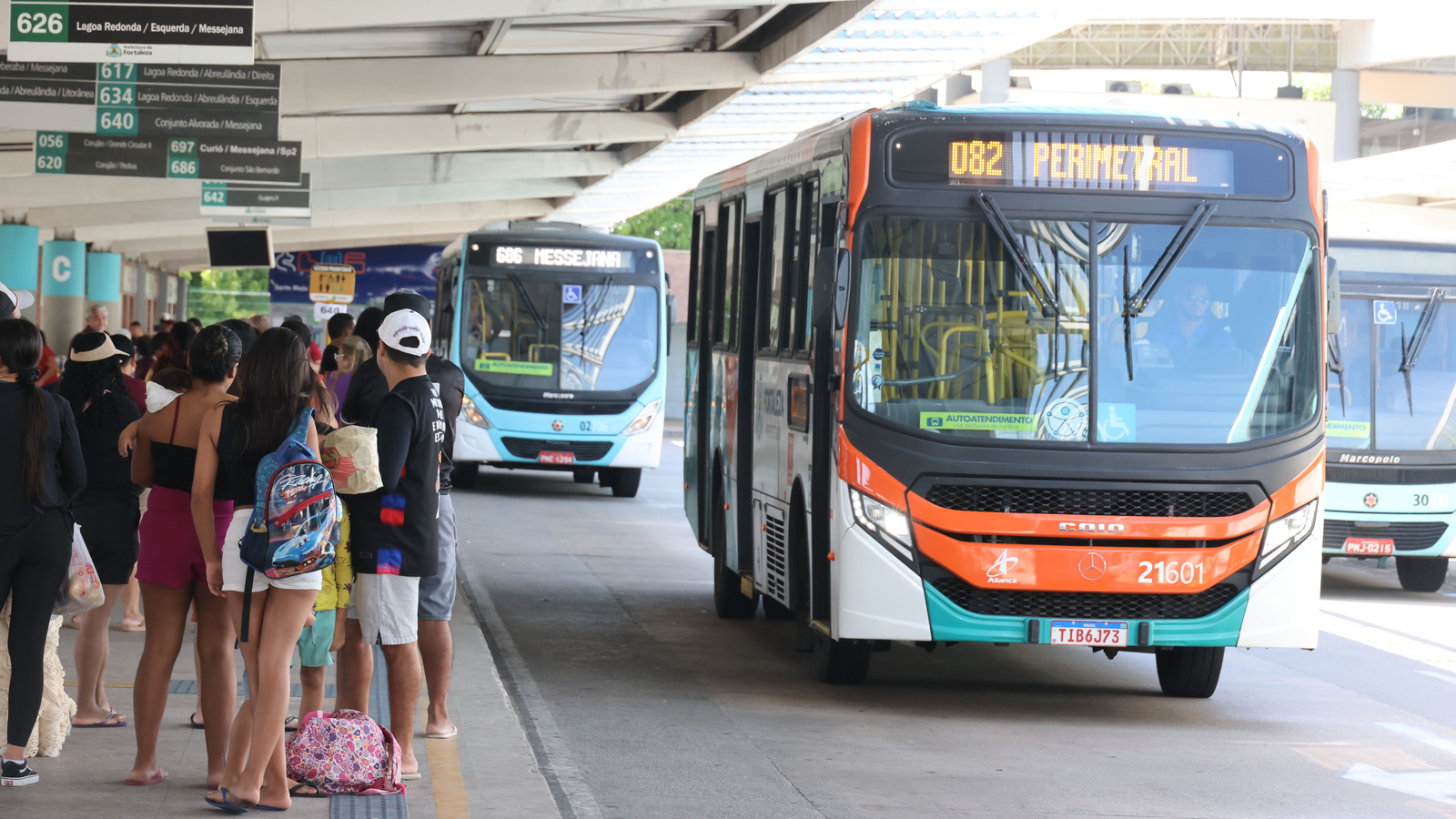 Passageiros em plataforma do Terminal Messejana, onde ao lado circulam ônibus